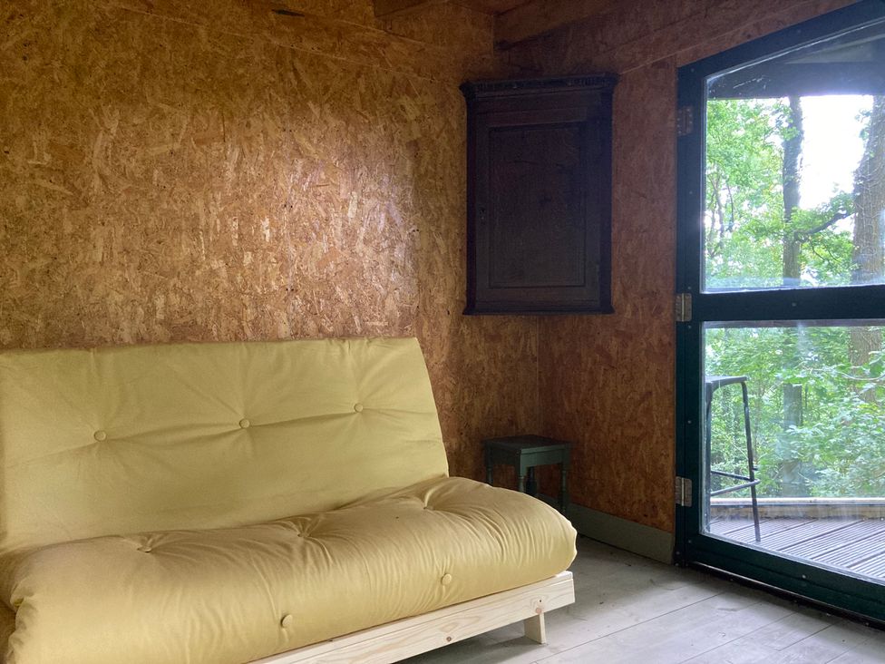 A snug with a yellow sofa and a cabinet at The Tree House in the Woods Longhope