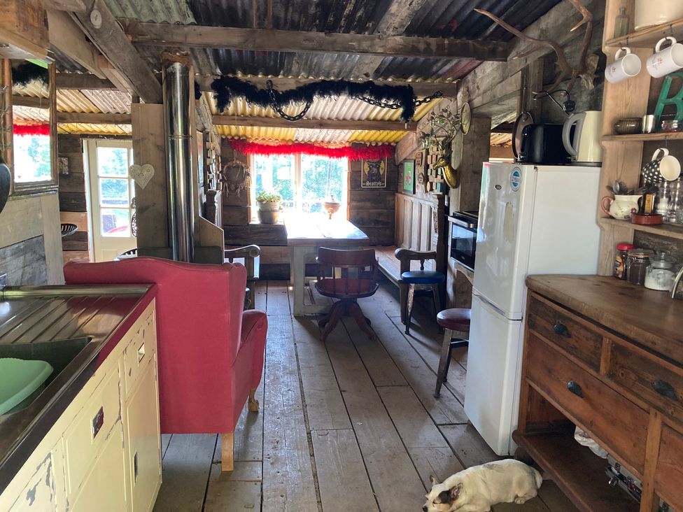 A kitchen with a table and chairs at Cosy Shepherd’s Hut Longhope