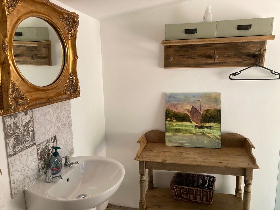 A bathroom with a sink and a wooden table at Cosy Shepherd’s Hut in Longhope