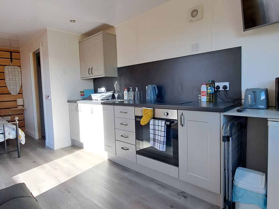 A kitchen with cabinets and appliances at The Posh Bothy in Roy Bridge