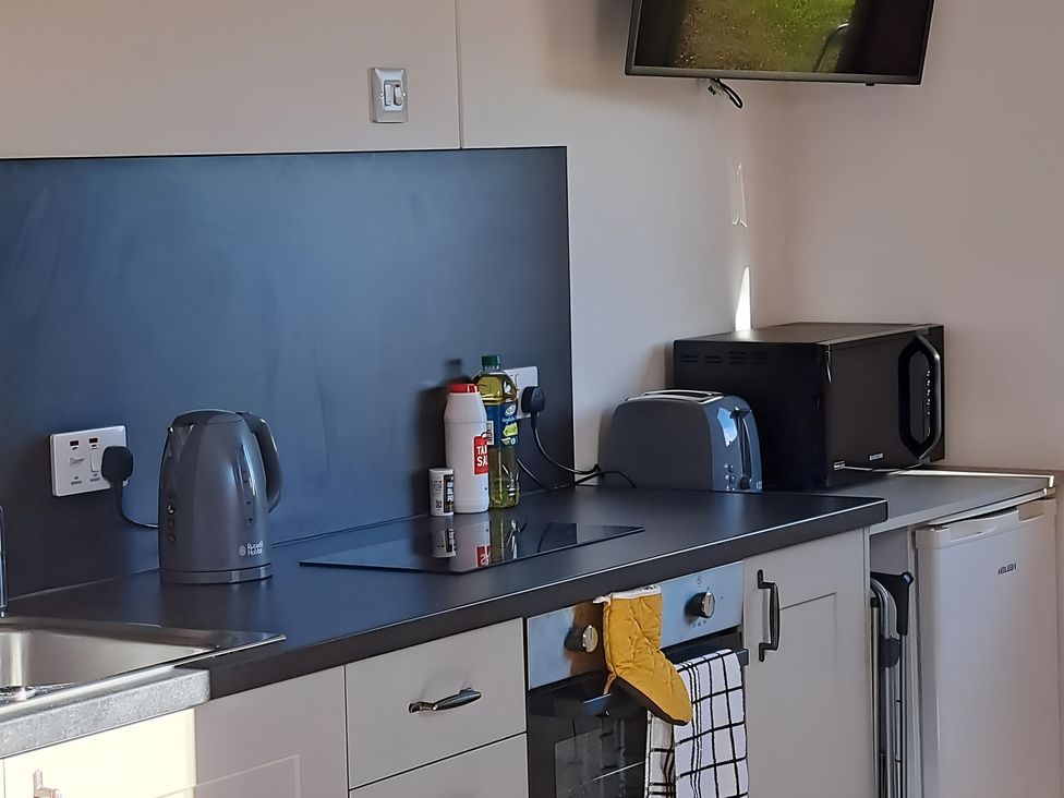 A kitchen with appliances including a microwave and kettle at The Posh Bothy 2 Roy Bridge