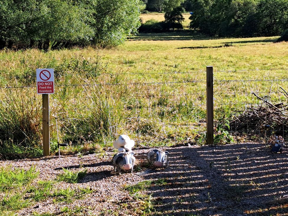 An outdoor area with a sign stating not to feed the livestock at The Posh Bothy 2 in Roy Bridge