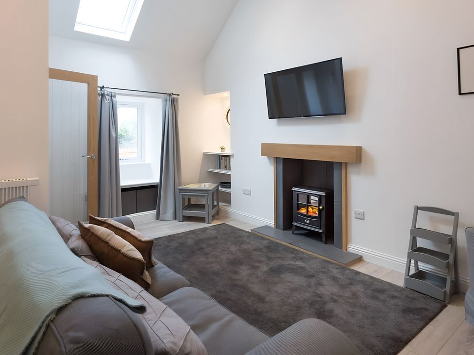 A living room with a sofa and television at Shedog Cottage Isle of Arran