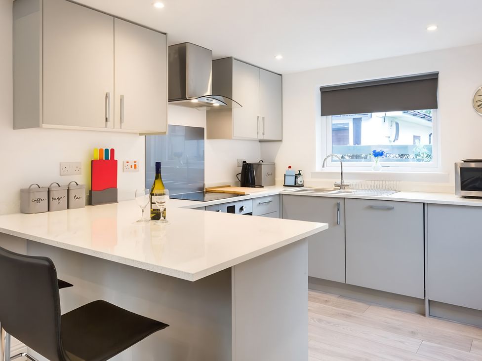 A kitchen with gray cabinets and countertop at Shedog Cottage Isle of Arran