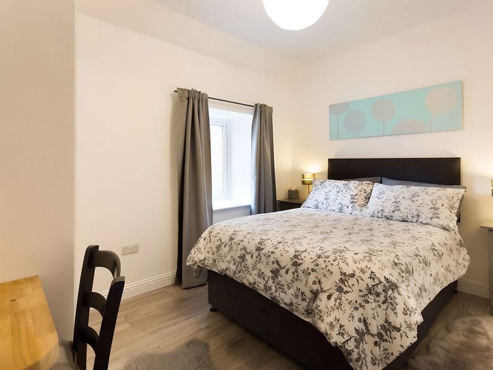 A bedroom with a bed and nightstand at Shedog Cottage, Isle of Arran