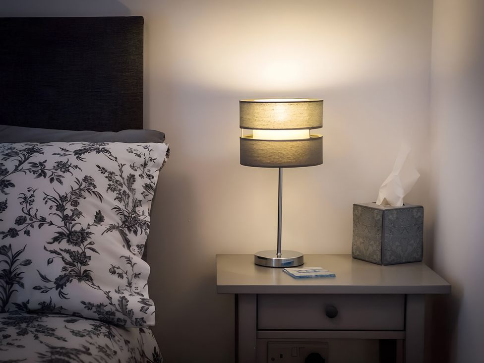 A bedroom with a lamp and a tissue box on a nightstand at Shedog Cottage Isle of Arran