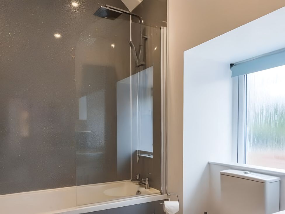 A bathroom with a bathtub and shower at Shedog Cottage Isle of Arran