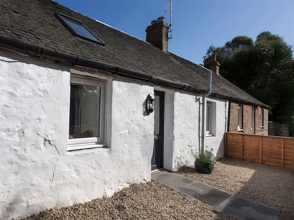An exterior view of a house with windows and a door at Shedog Cottage Isle of Arran