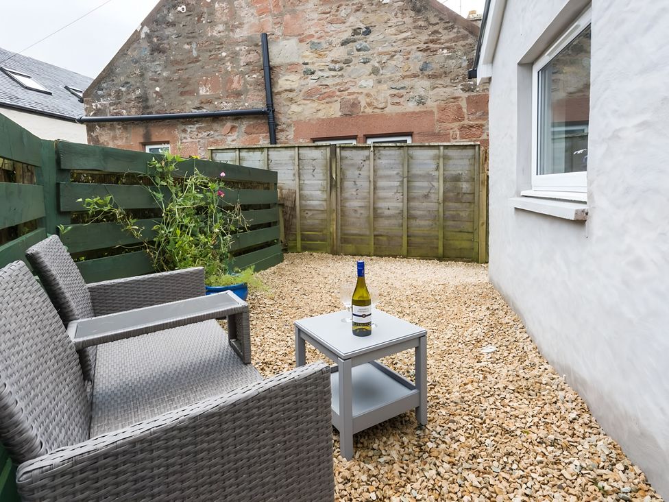 An outdoor area with seating and a table at Shedog Cottage Isle of Arran