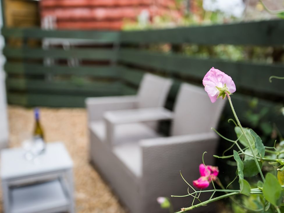 A seating area with chairs and a table in a garden at Shedog Cottage Isle of Arran