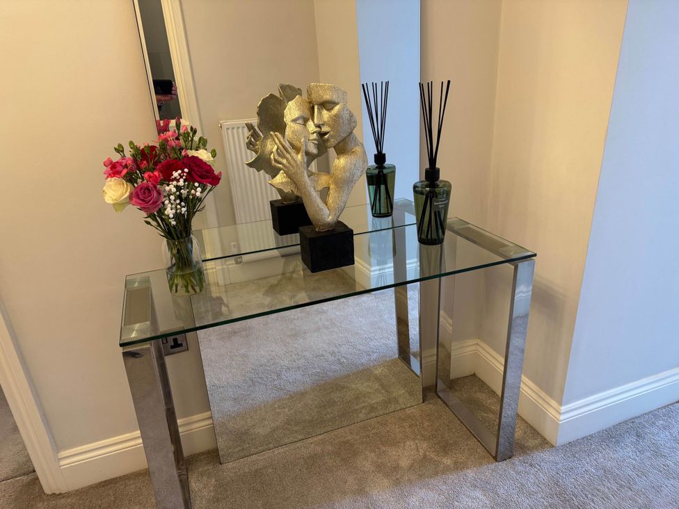 A console table with a sculpture and flowers at Apartment 2 Preston, Lancashire