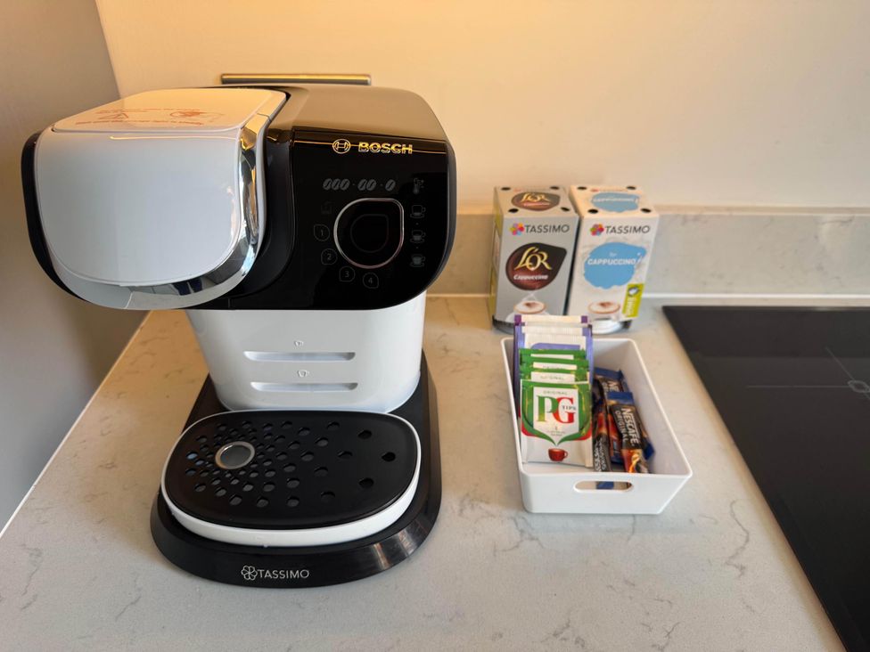 A coffee machine with pods and tea bags in a kitchen at Apartment 2 Preston, Lancashire
