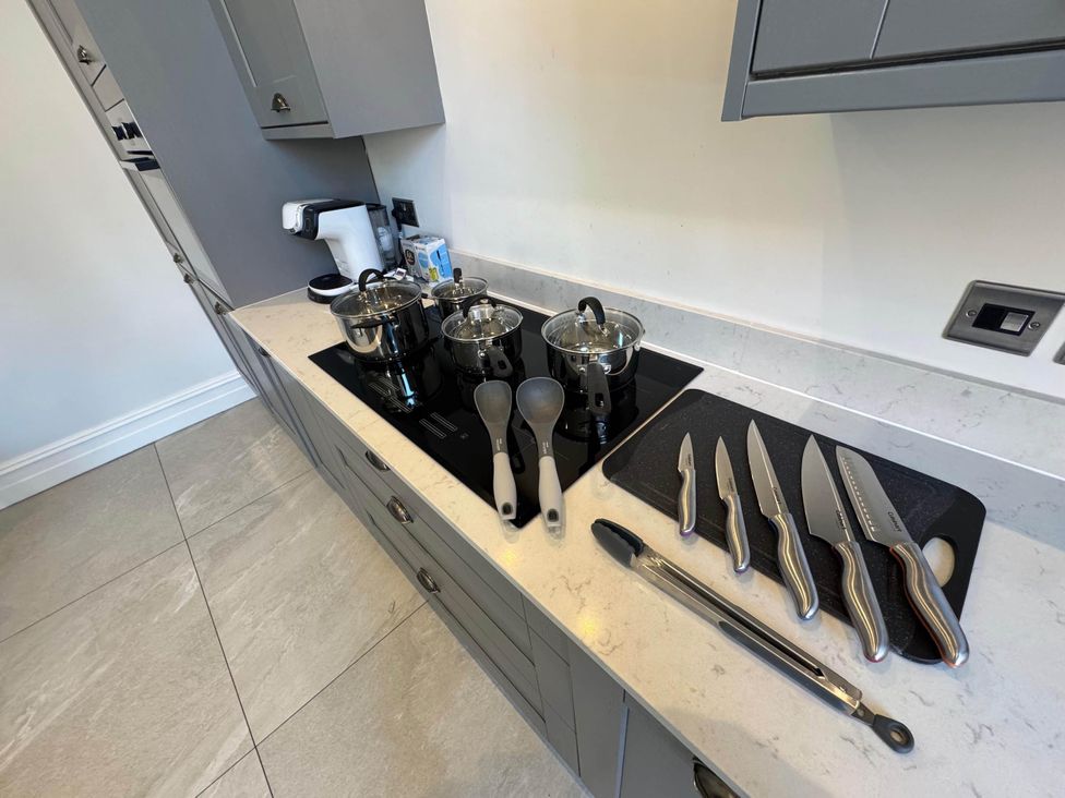 A kitchen with pans and knives on a countertop at Apartment 2, Preston, Lancashire