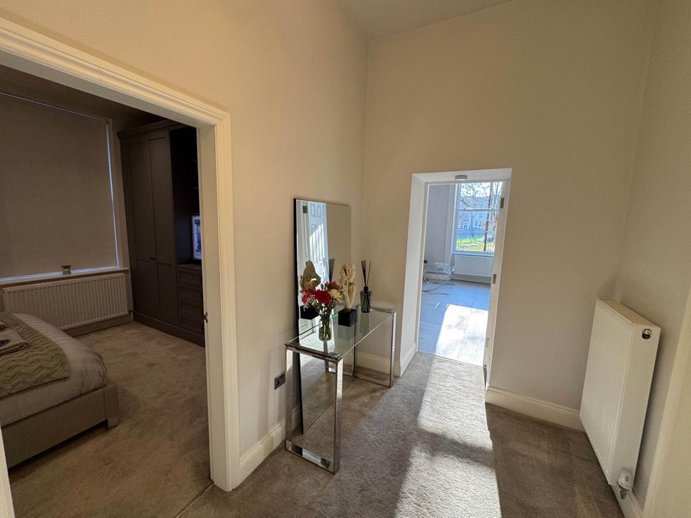 A hallway with a console table and a bedroom door at Apartment 2 in Preston, Lancashire