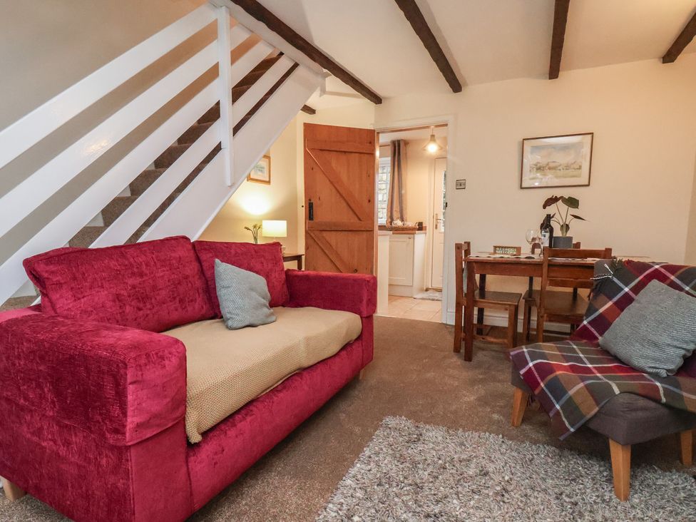 A living room with a sofa and dining table at 4 Lilac Cottages