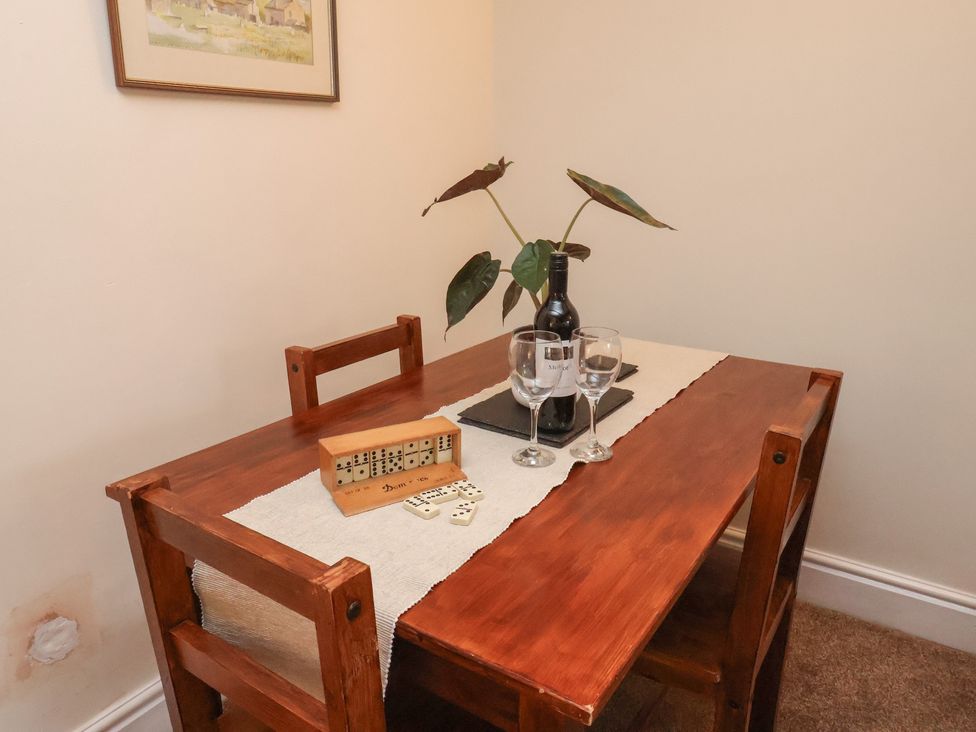 A dining room with a wooden table and chairs at 4 Lilac Cottages