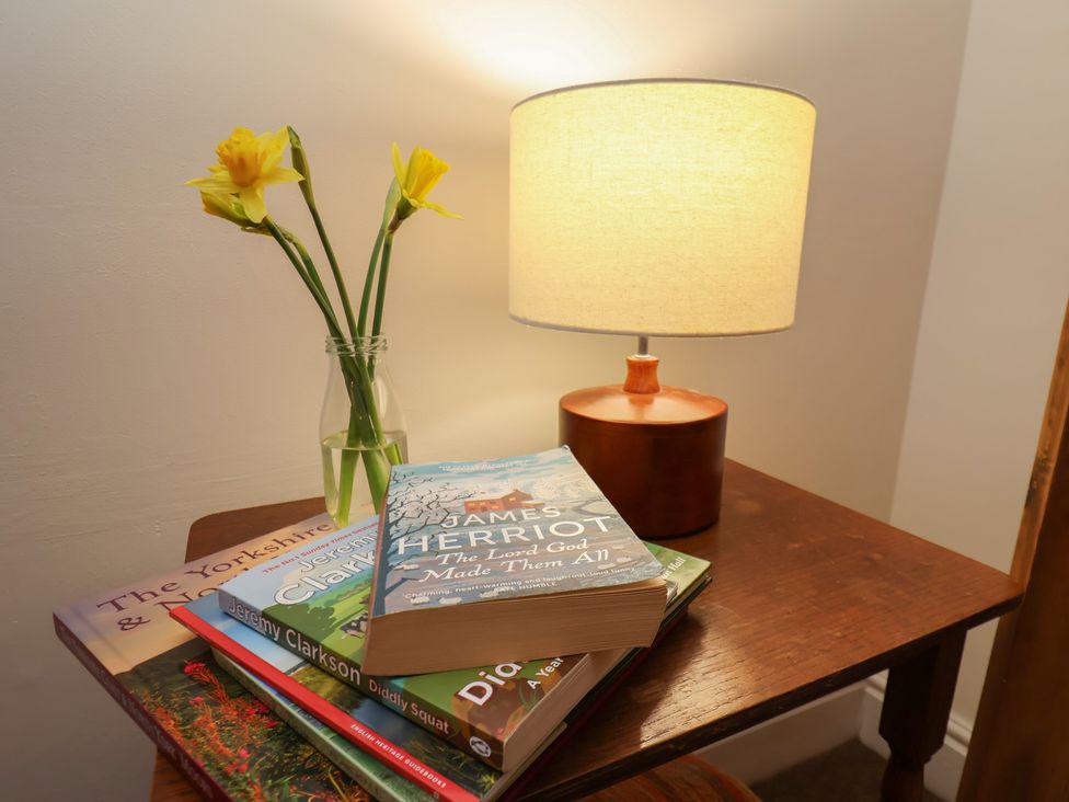 A table with books and a lamp at 4 Lilac Cottages