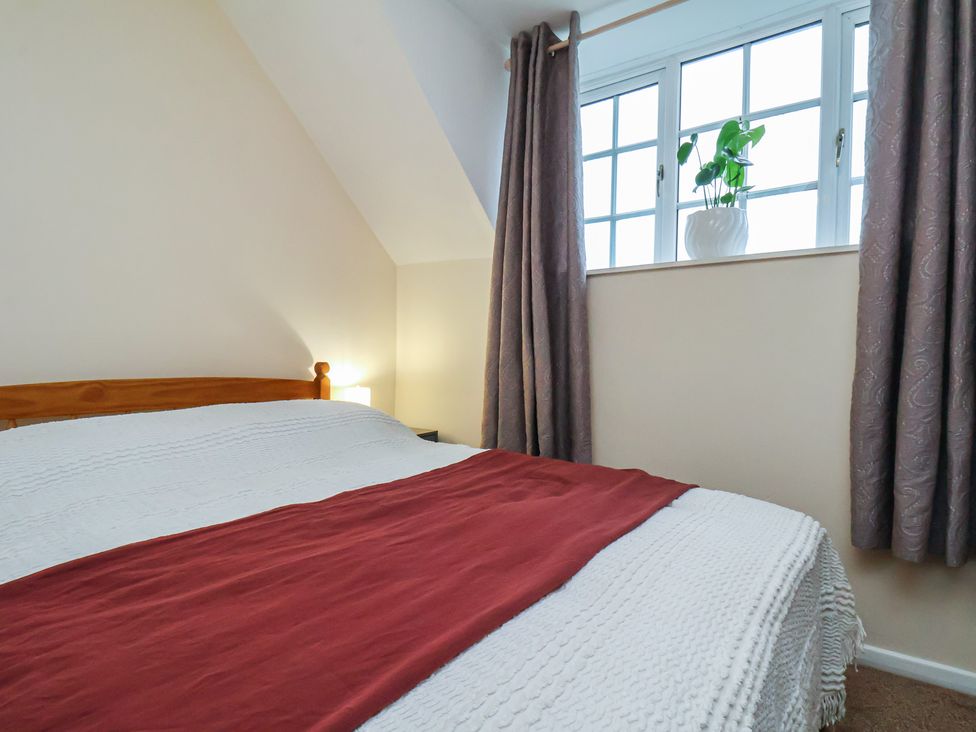 A bedroom with a bed and window at 4 Lilac Cottages