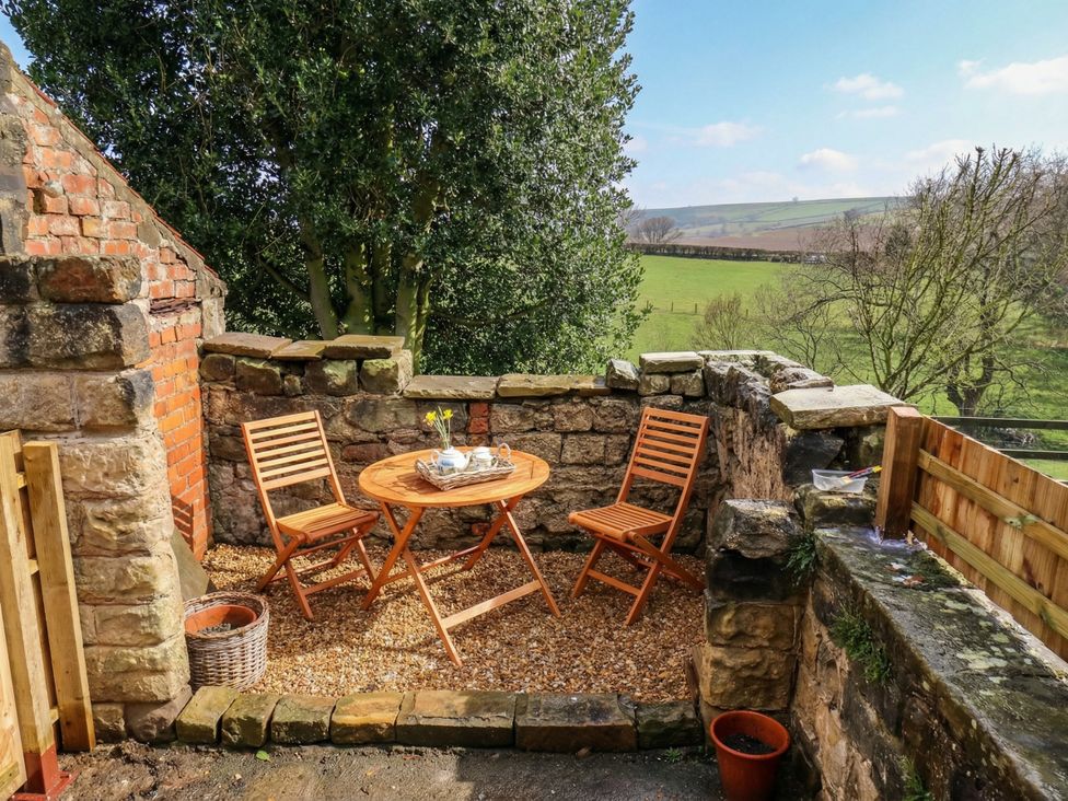 A table and chairs in an outdoor area at 4 Lilac Cottages
