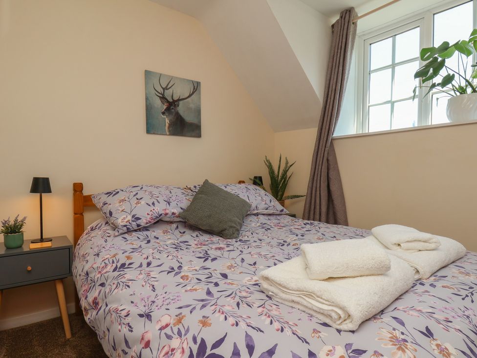 A bedroom with a bed and bedside table at 4 Lilac Cottages Ainthorpe