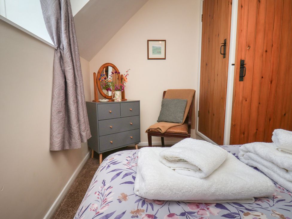 A bedroom with a bed and dresser at 4 Lilac Cottages Ainthorpe