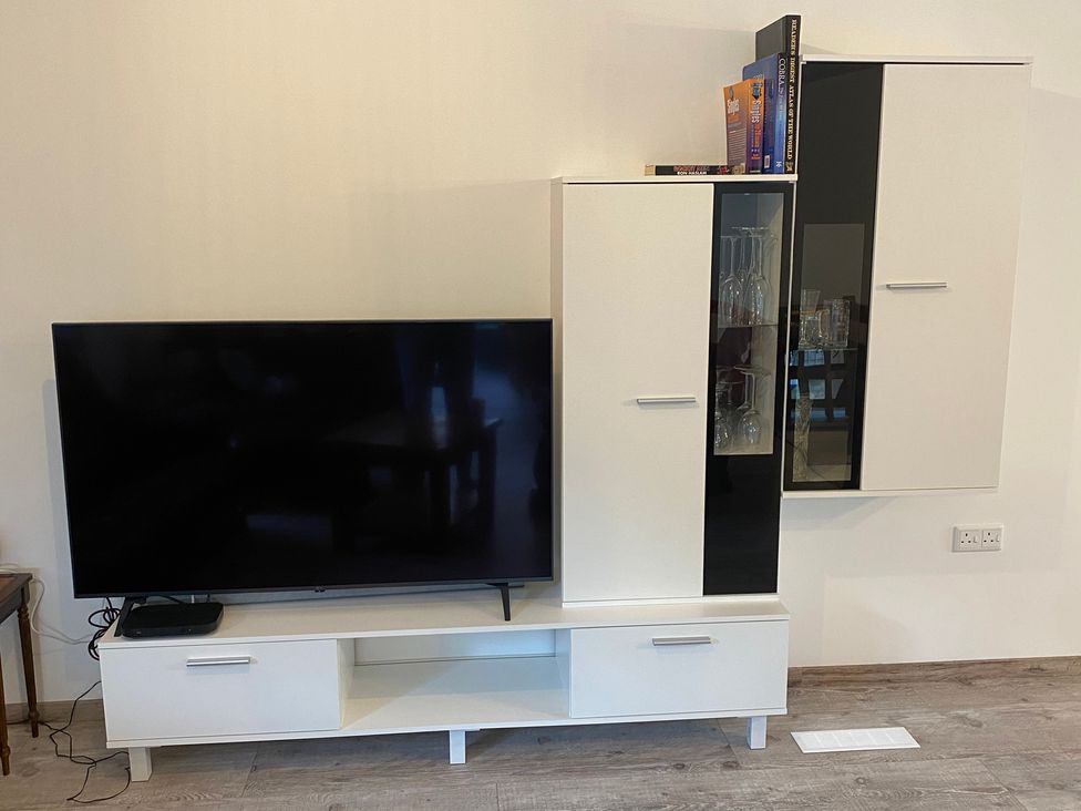 A television and shelf unit in the living room at Pityme-Not Wadebridge