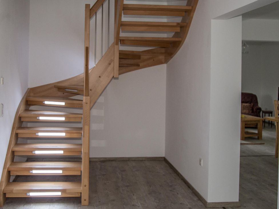 A staircase with wooden steps and a handrail at Pityme-Not Wadebridge