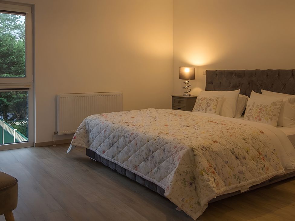 A bedroom with a bed and a lamp at Pityme-Not Wadebridge