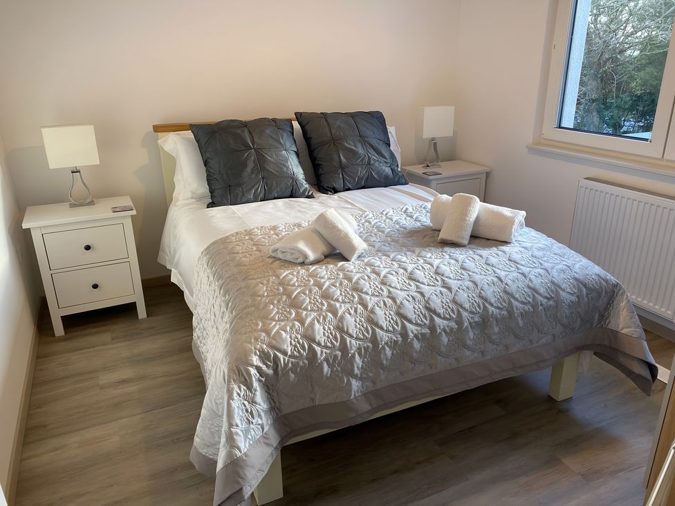A bedroom with a bed and bedside tables at Pityme-Not Wadebridge