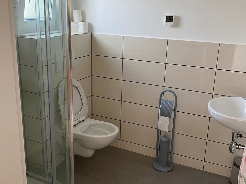 A bathroom with a shower, toilet, and sink at Pityme-Not Wadebridge