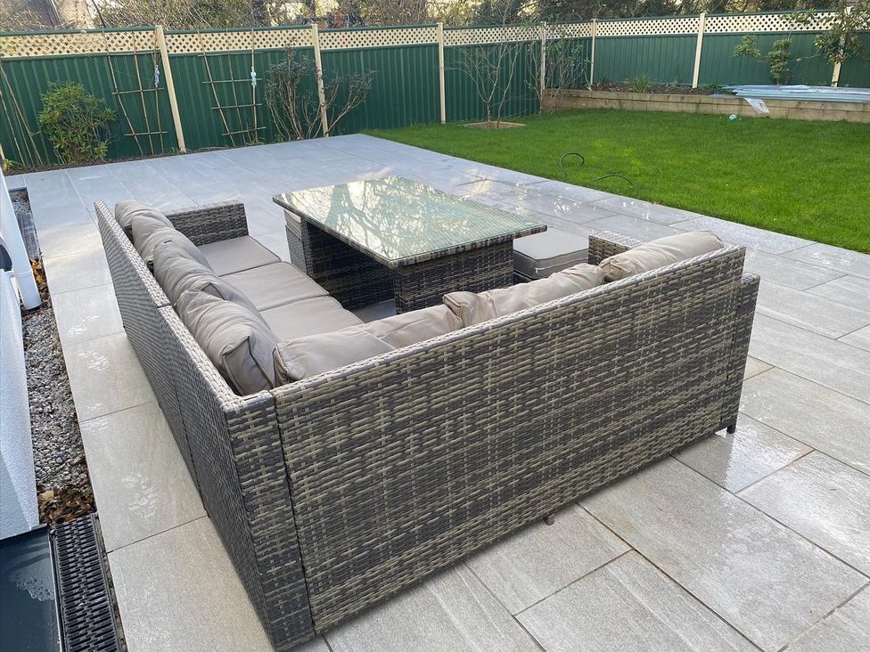 A garden with an outdoor sofa and coffee table at Pityme-Not in Wadebridge