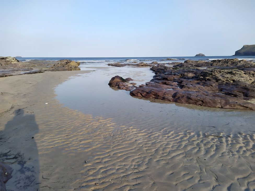 A beach with rocks and water at Pityme-Not in Wadebridge