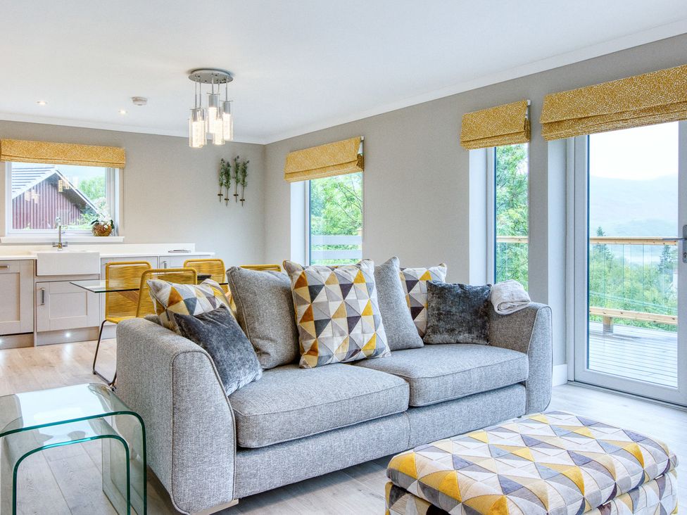A living room with a sofa and coffee table at Pinemarten Lodge in Crianlarich