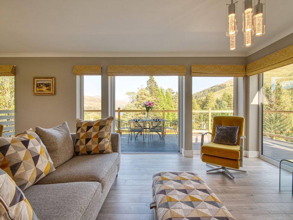 A living room with a sofa and a table at Pinemarten Lodge in Crianlarich