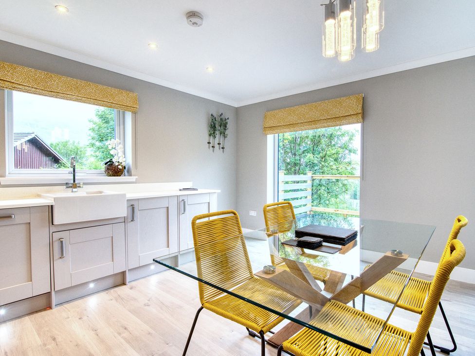 A kitchen with a sink and dining area at Pinemarten Lodge in Crianlarich