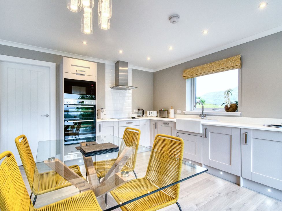 A kitchen with a table and chairs at Pinemarten Lodge Crianlarich