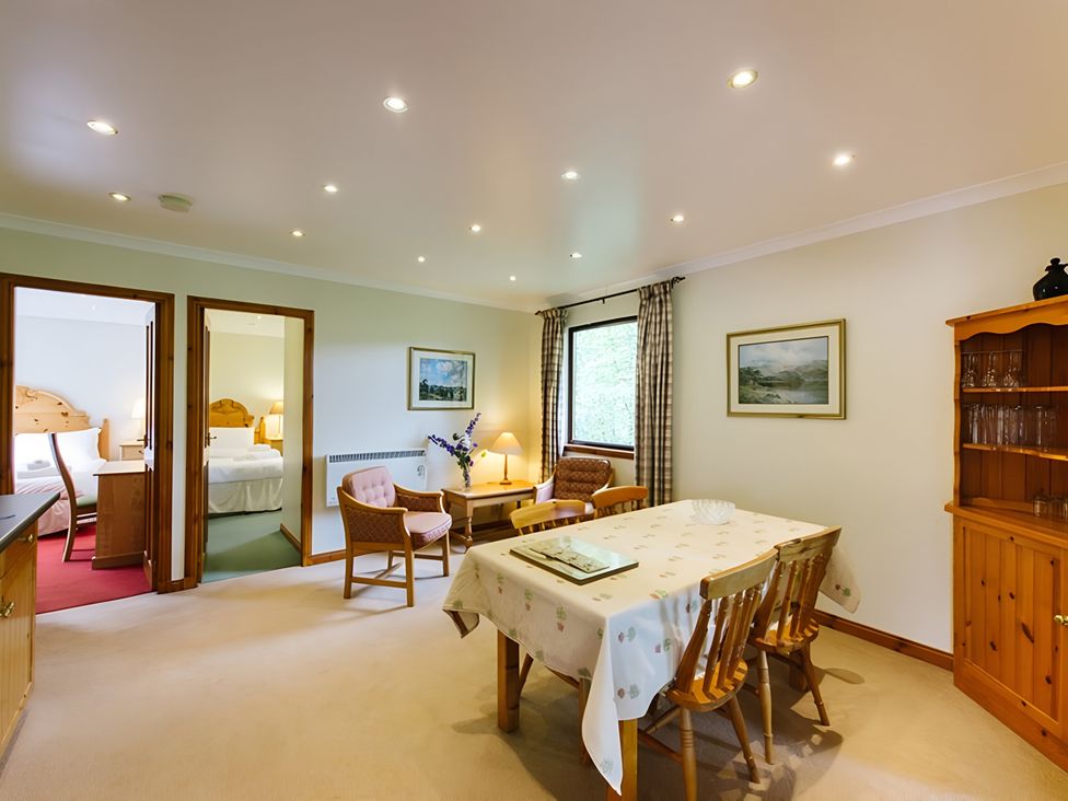 A dining room with table and chairs at Buzzard Lodge in Crianlarich
