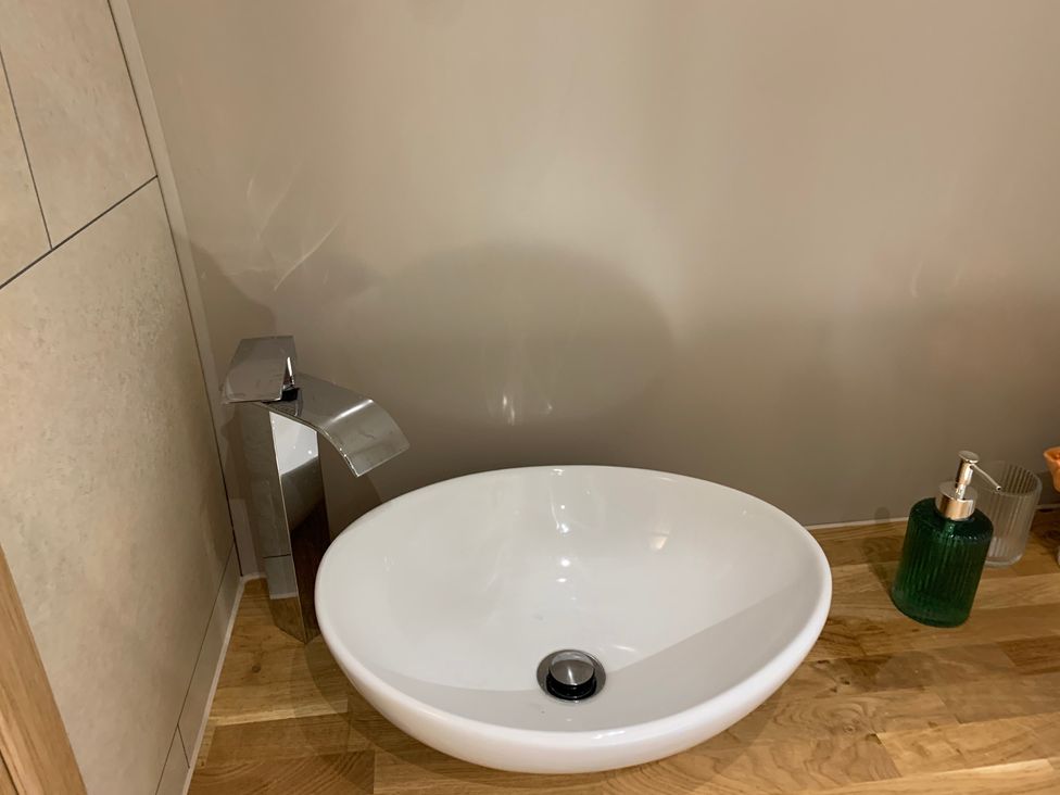 A sink with a faucet and soap dispenser at Cosy Escape in Sheerness