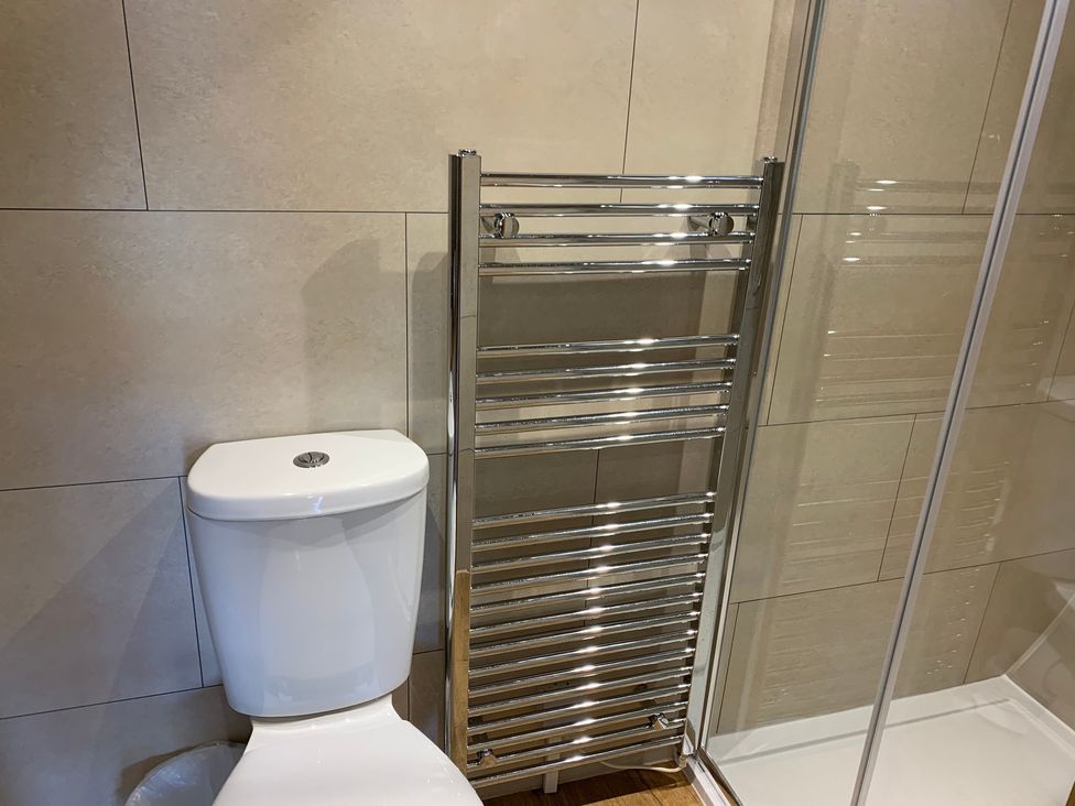 A bathroom with a toilet and a towel rail at Cosy Escape in Sheerness