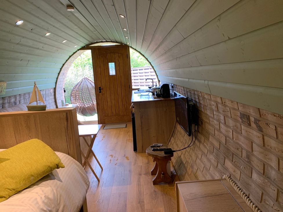 A kitchenette and bed in a curved room at Cosy Escape in Sheerness