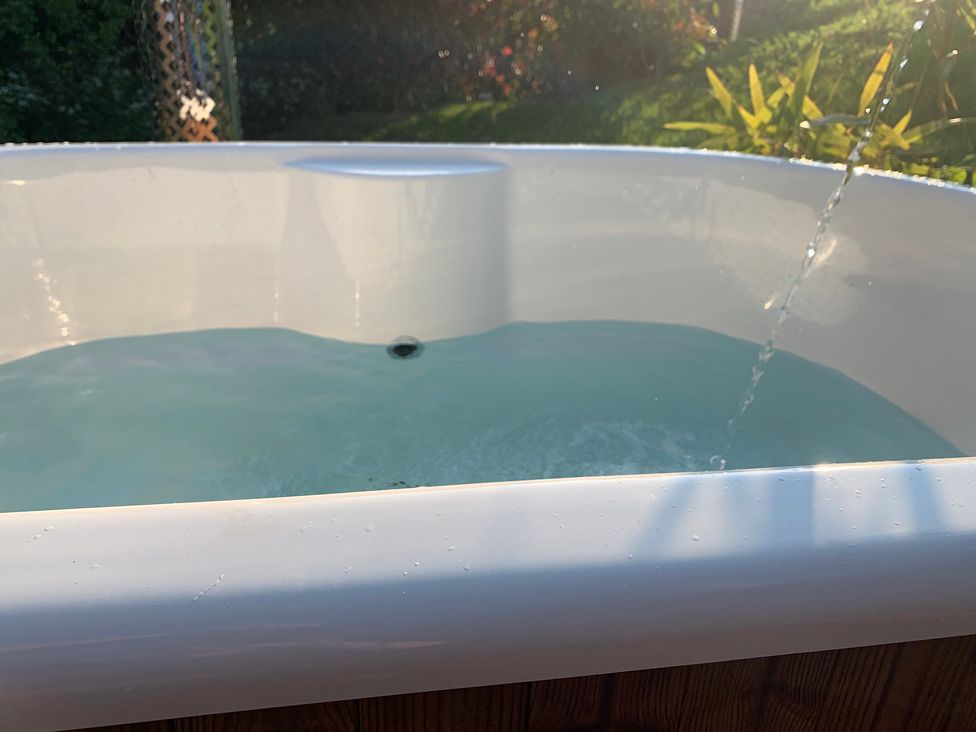 A hot tub with water and a spray in an outdoor setting at Cosy Escape in Sheerness
