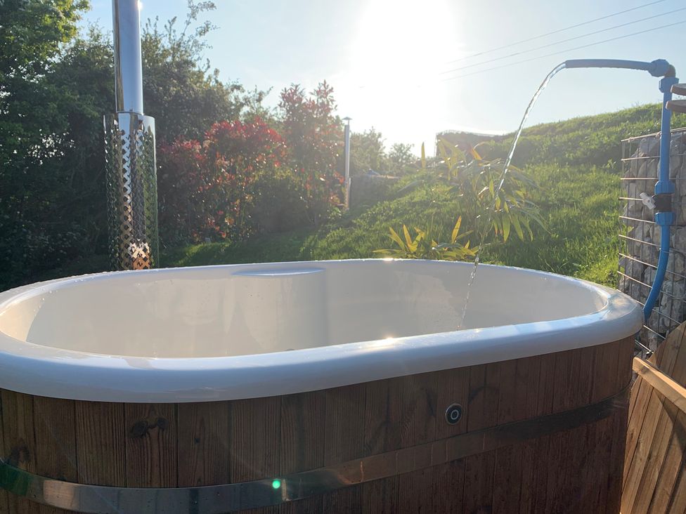A bathtub with a water spout in a garden at Cosy Escape Sheerness