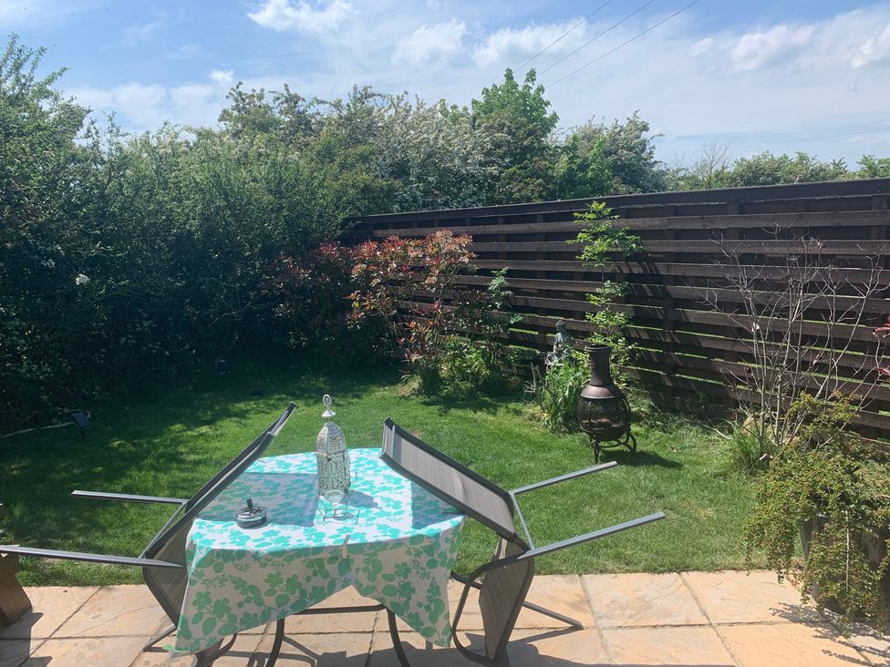 A table with chairs and plants in the garden at Cosy Escape in Sheerness