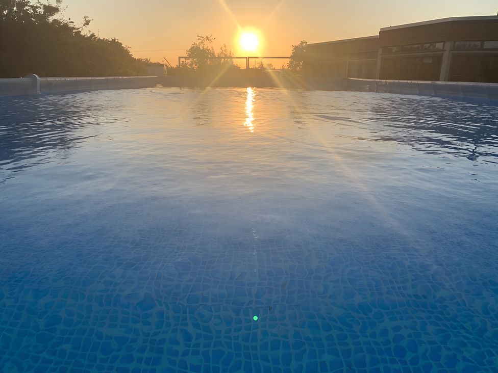A pool with water reflecting the sunset at Cosy Escape in Sheerness