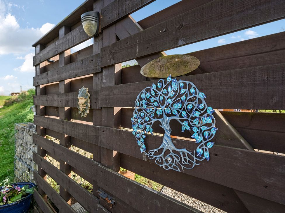 A wooden fence with decorative wall art at Cosy Escape Minster On Sea