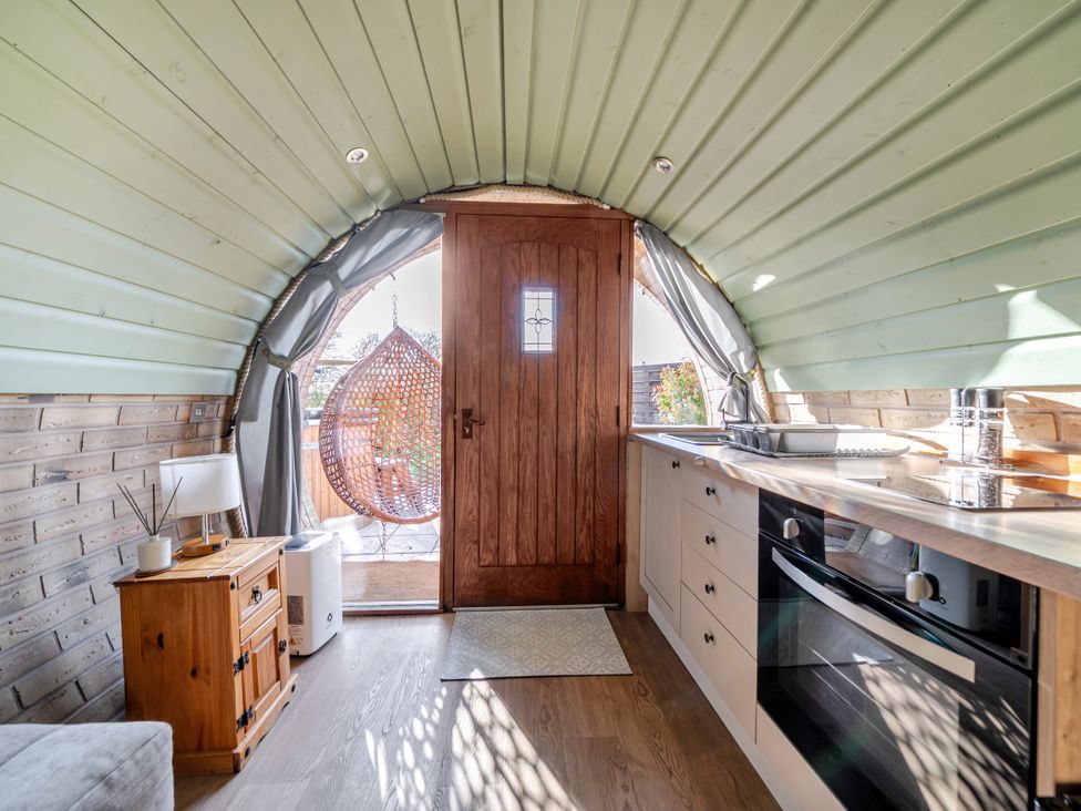 A kitchen with a counter and hanging chair at Cosy Escape in Minster On Sea
