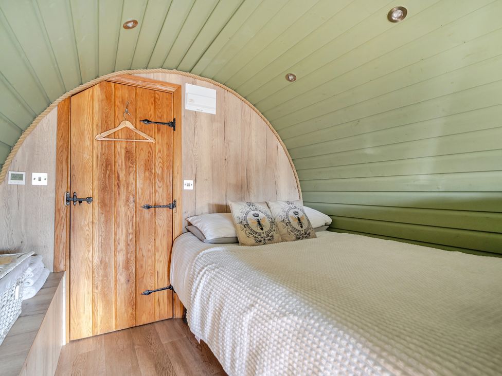 A bedroom with a bed and wooden door at Cosy Escape in Minster On Sea
