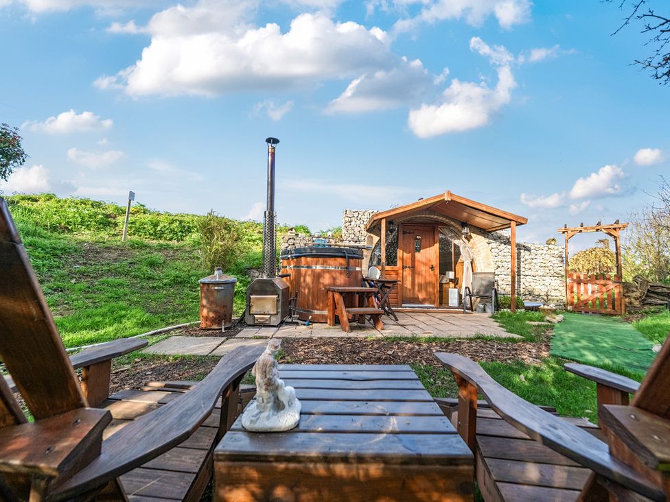 A wooden table and chairs with a hot tub at Cosy Escape in Minster On Sea
