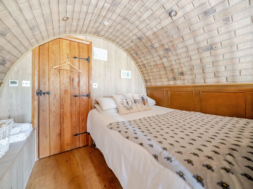 A bedroom with a bed and wooden door at Cosy Escape in Minster On Sea