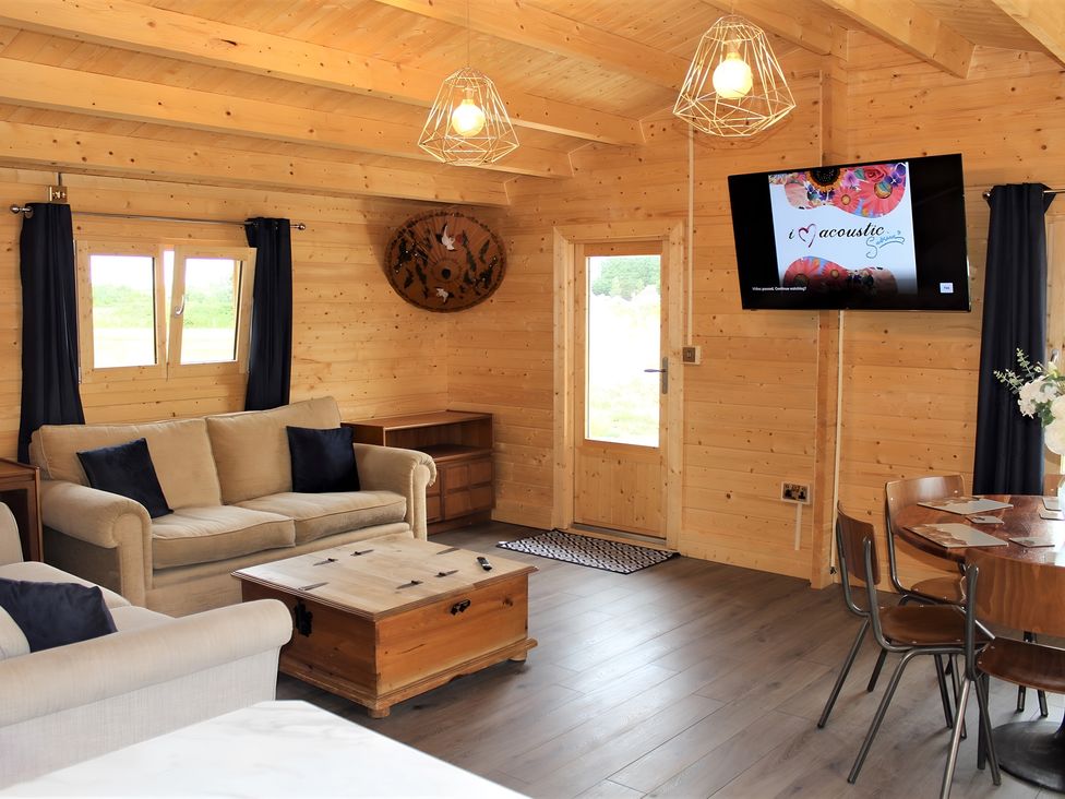 A living room with a sofa and television at Cotswold Nights Away Evesham